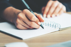 Woman writing in notepad